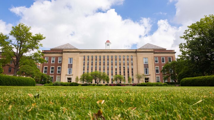 A green lawn is seen south of Love Library on a partly cloudy day.