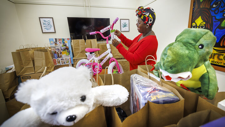 Domonique Cudjo, assistant director, Gender and Sexuality Center, attaches a gift tag to a bicycle being given to a little Husker.
