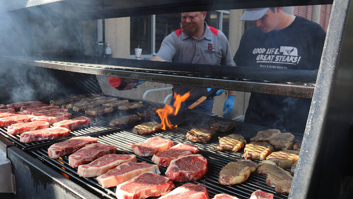 Two men grilling steaks