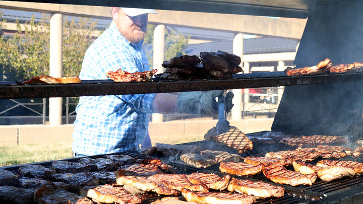 Faculty member Benny Mote helps prepare steaks at the 2022 Block and Bridle Steak Fry