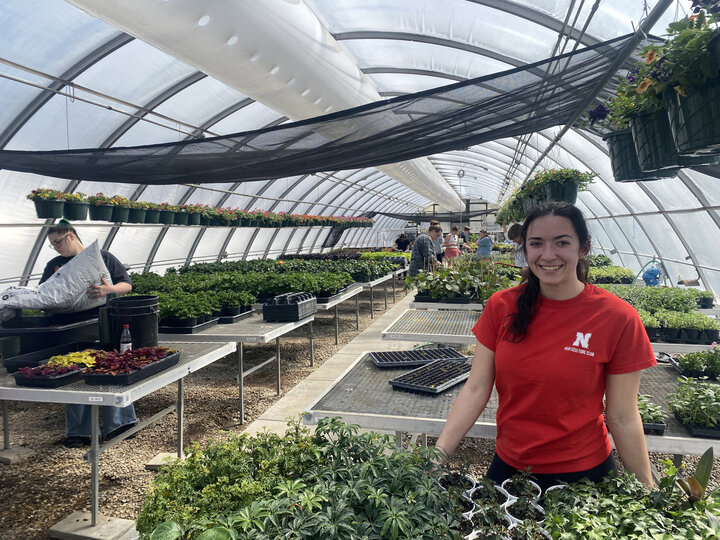 A student in the Horticulture Club working in the greenhouse on campus