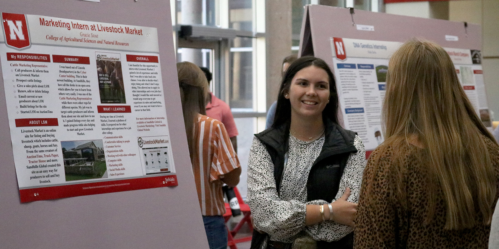 Two students discussing an internship experience poster